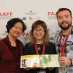 Pangia Pangia, Chigumi Obayashi, and Festival Director Rob Buscher holding a PAAFF 2016 program book