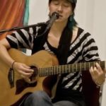 Woman singing and playing guitar at PAAFF 2008