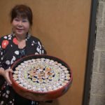 Madame Saito holding a sushi tray
