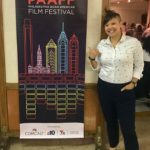 Quynh-Mai Nguyen standing with the PAAFF 2018 banner