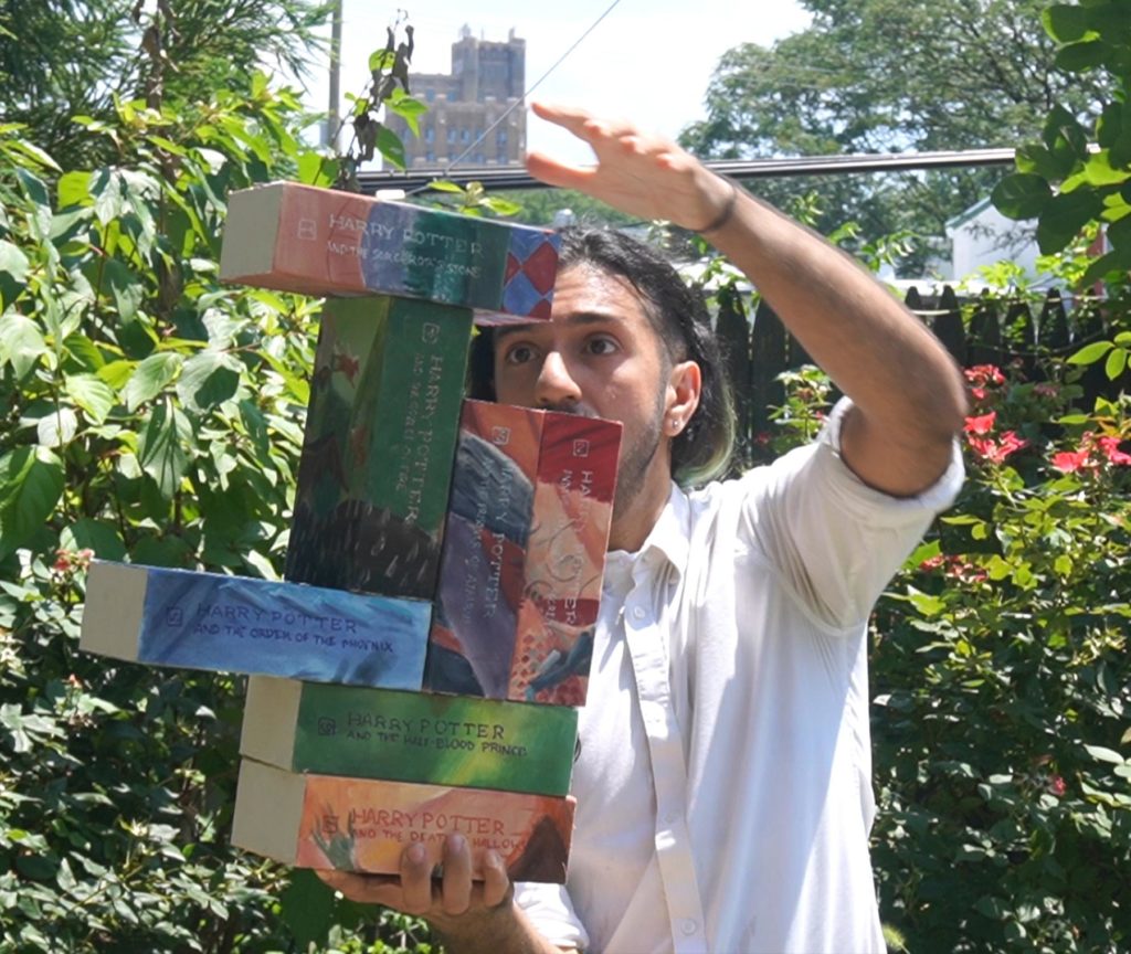 Joseph Ahmed balancing Harry Potter books