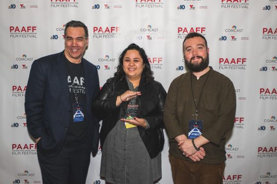Cecilia Mejia holding her trophy for Best Narrative Feature with Michael Wingate-Jones and Rob Buscher at PAAFF 2019