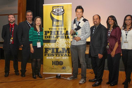 Photo of Brian Yung holding his Rising Star award with the PAAFF Staff